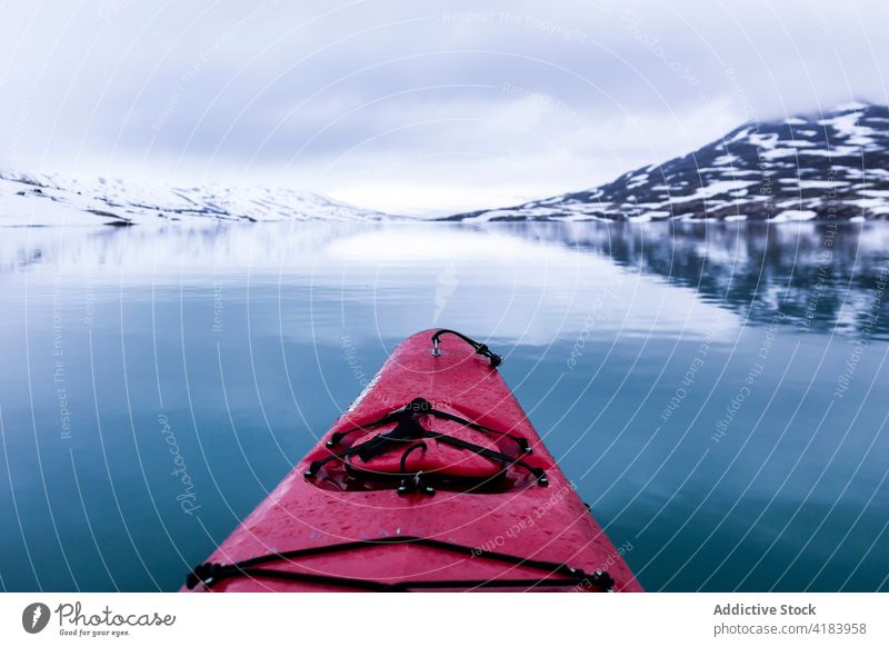 Canoe on river in winter canoe winery float kayak snow mountain highland water norway calm red color boat terrain weather landscape ridge tranquil nature scenic