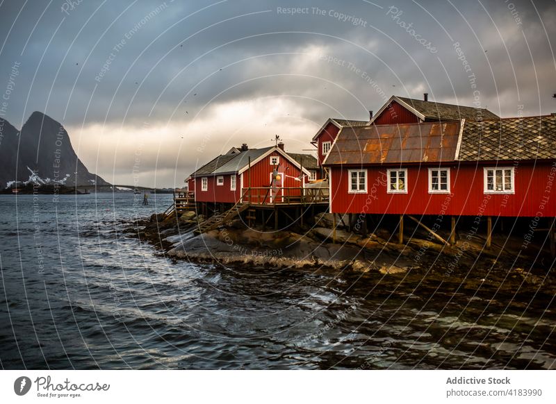 Wooden houses in fishing village near sea residential wooden cloudy sky seashore building norway mountain settlement peaceful serene scenic tranquil cabin water