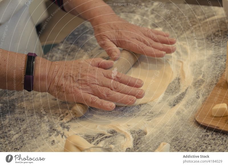 Crop chef rolling out pastry crust on table in house cook roll out culinary recipe menu flour kitchen home process rolling pin prepare ingredient natural