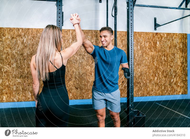 Trainer helping disabled sportsman in workout handicapped high five trainer gym assisting resilience support instructor friend looking at each other training
