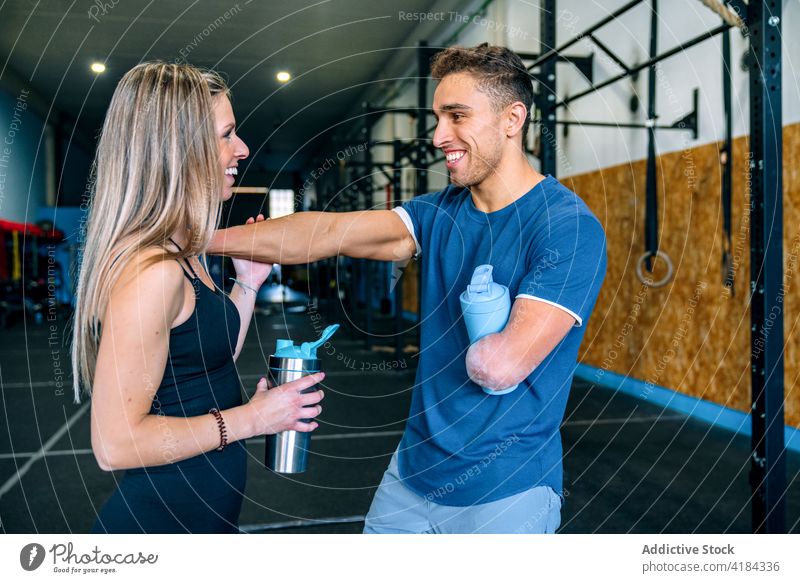 Sportspeople drinking beverage during training in gymnasium sportspeople thirsty workout refreshment break man woman sportsman water bottle disabled together