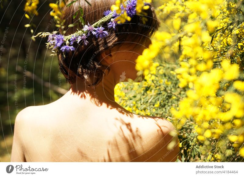 Naked female enjoying smell of blooming tree in garden woman relax wreath harmony nature idyllic flower blossom bare shoulders peaceful rest serene flora growth