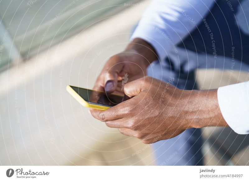 Hands of unrecognizable black man using a smartphone. businessman guy african background worker adult person male american outdoor copyspace cell communication