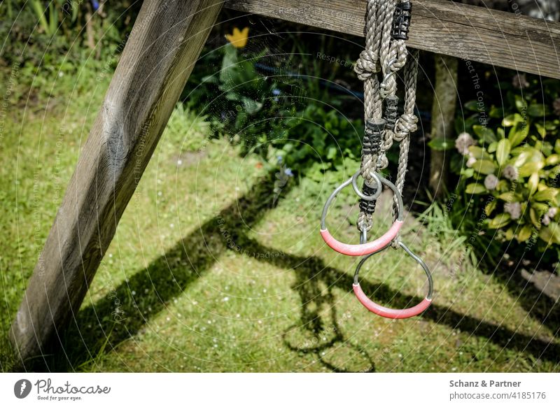 Gymnastic rings hanging from children's swing in the garden Garden Home Rings Swing Meadow Lawn Playground private garden Detached house Playing Movement
