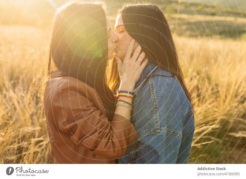 Couple of women kissing in field lesbian couple tender love together relationship lgbt lgbtq homosexual enjoy in love affection girlfriend eyes closed bonding