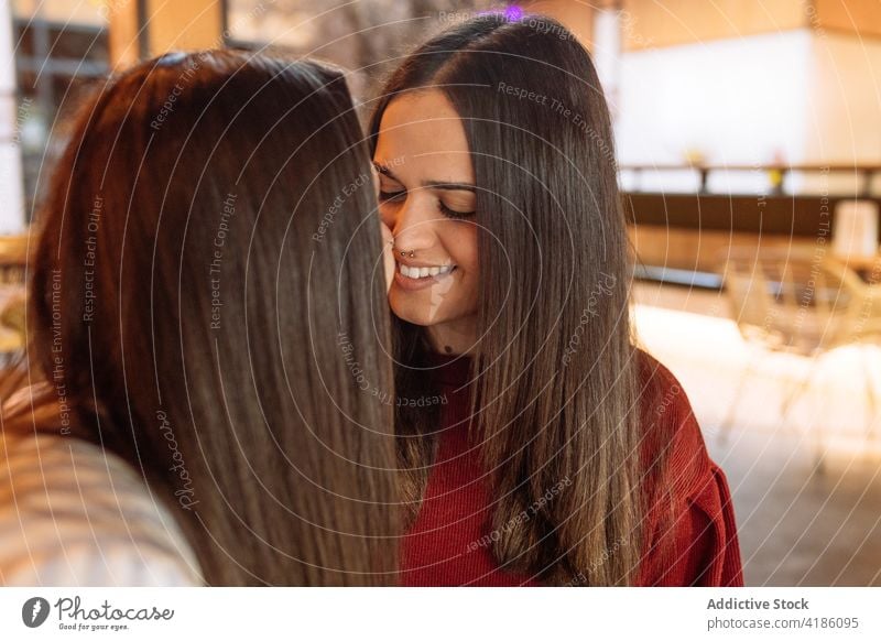 Couple of women kissing in cafe lesbian couple tender love together relationship lgbt lgbtq homosexual enjoy in love affection girlfriend sit eyes closed