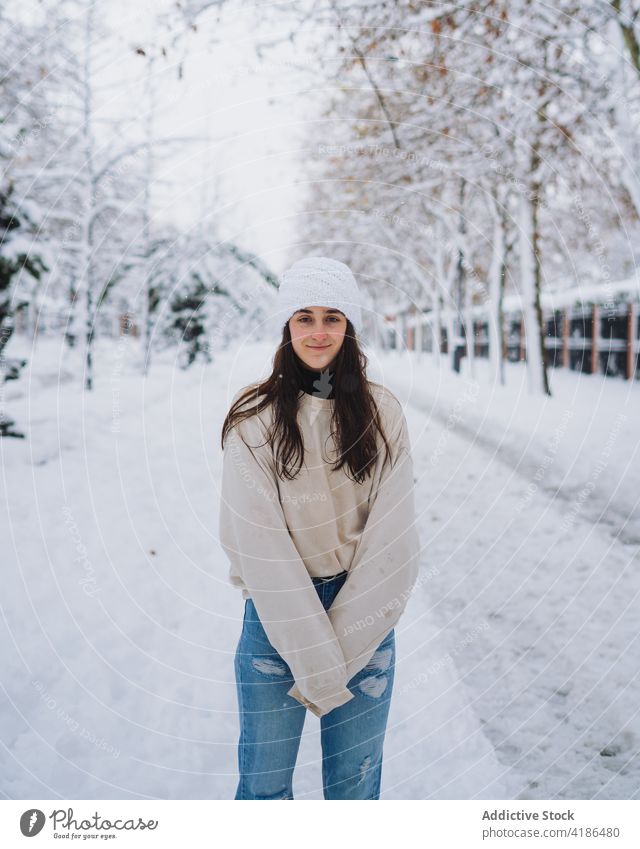 Woman on snowy road in winter city woman sky spare time weekend cold weather spain madrid alone vegetate tree lamp post footprint route direction building trace