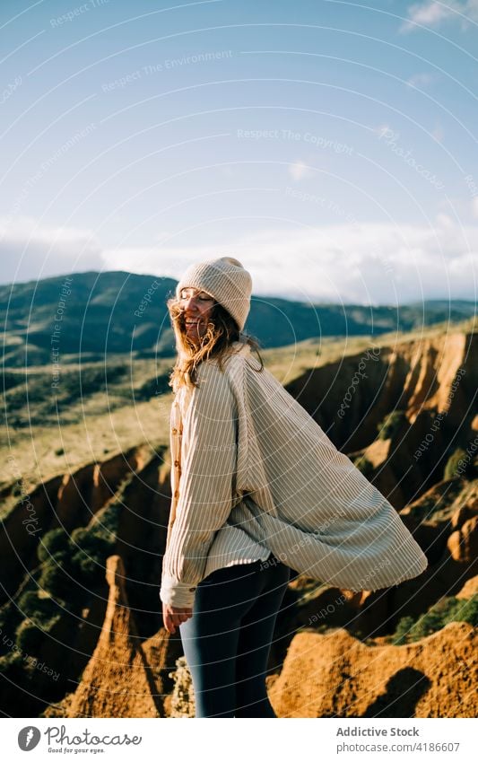 Happy female traveler admiring ridges from canyon in sunlight contemplate highland landscape nature woman tourism rest majestic stand admire vacation journey