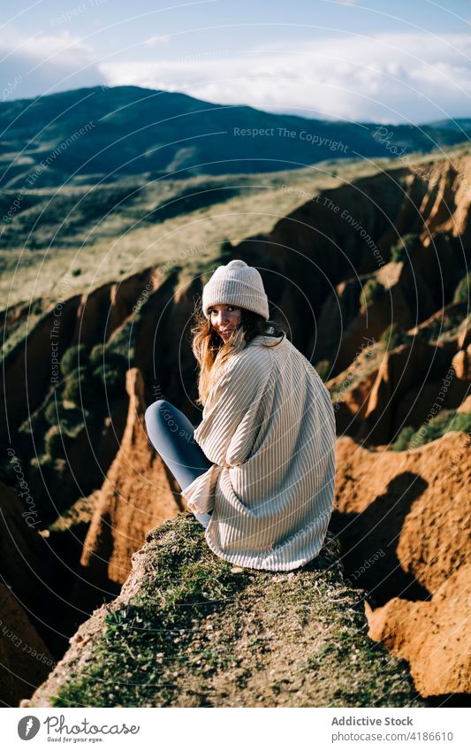 Happy female traveler admiring ridges from canyon in sunlight contemplate highland smile landscape nature woman tourism rest happy majestic admire vacation