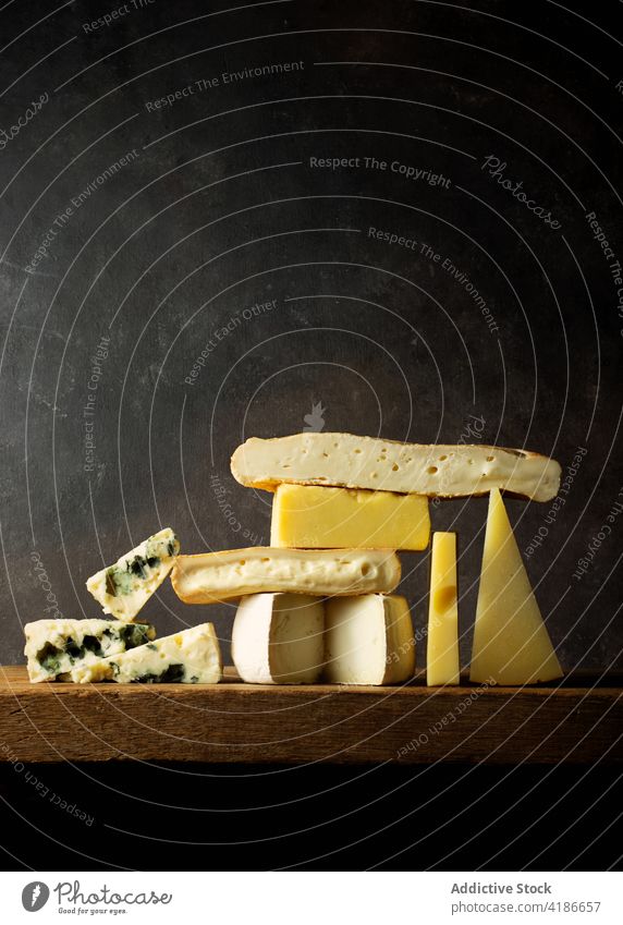Various cut cheese on wooden board placed on wooden table dinner knife black breakfast cutting organic market assorted view stack roquefort cheese