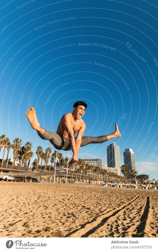 Strong man jumping high during outdoor workout sportsman power strong training exercise scream leap fitness young asian ethnic shirtless intense lifestyle
