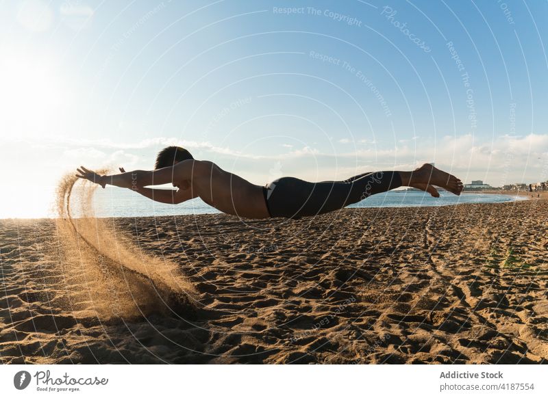 Sporty man levitating over sand during workout sportsman levitate beach jump training sporty active exercise fly activity lifestyle energy athlete leap lying