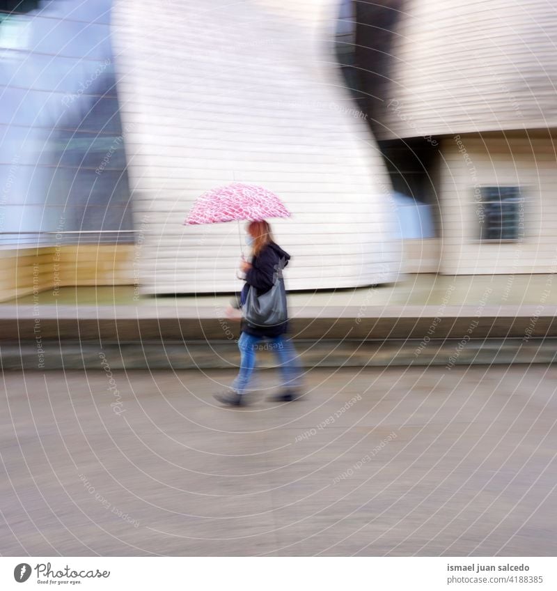 blurred woman with an umbrella in rainy days in Bilbao city, Spain adult one person raining water human pedestrian street urban bilbao spain walking lifestyle