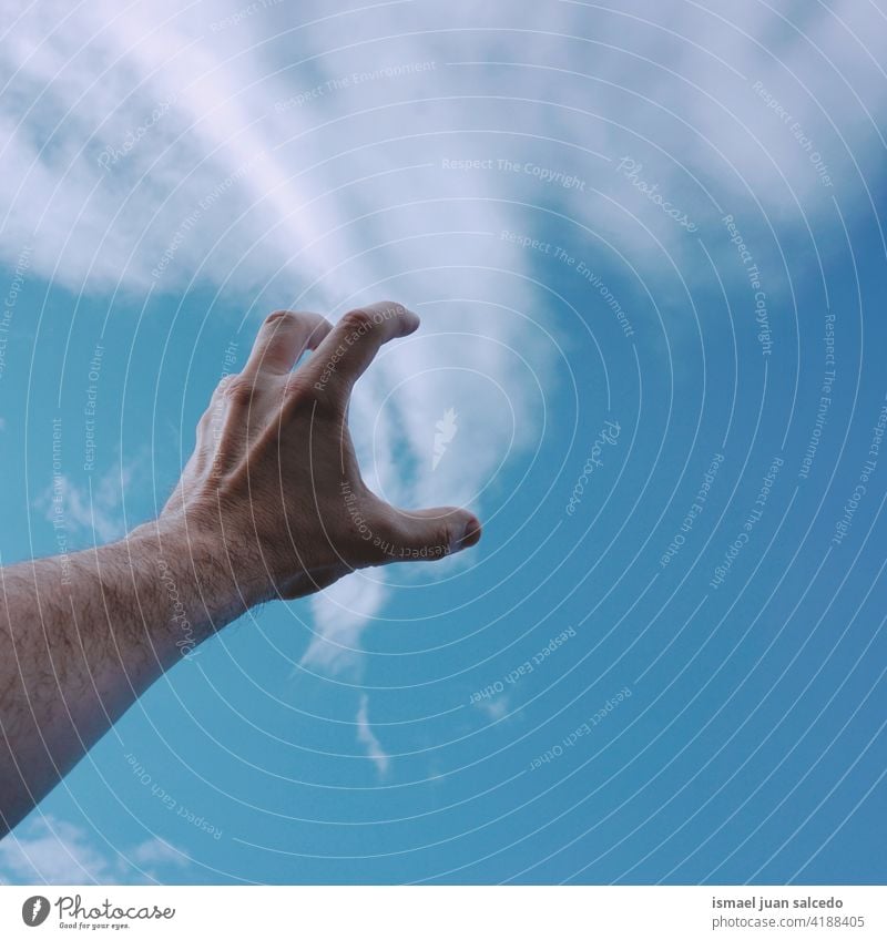 hand up touching the clouds arm fingers skin palm body part sky blue sun sunlight feeling reaching pointing gesture gesturing concept freedom Palm of the hand