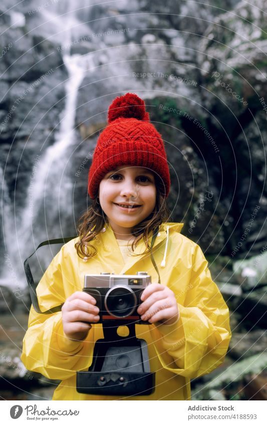 Happy teen taking photo on camera against waterfall on mountain take photo photo camera nature memory highland trip using device dynamic girl cascade travel