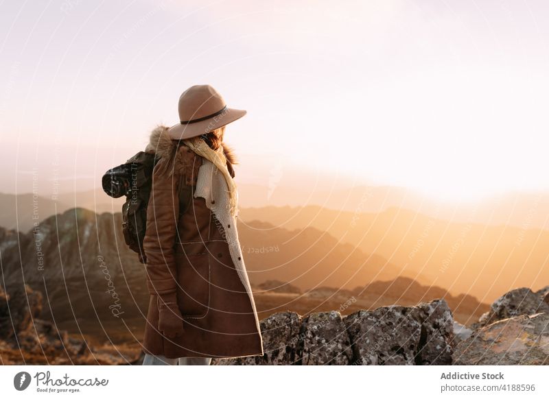 Traveler in hat standing on rock in mountains traveler viewpoint observe highland hiker enjoy admire explore amazing scenery valley trekking adventure sunny