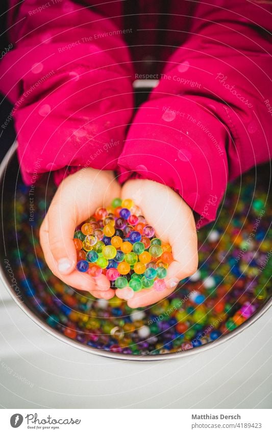 Girl playing with water beads Child Hand Children`s hand children's hands Handicraft Muding Playing water pearls variegated colourful Infancy Toddler Fingers