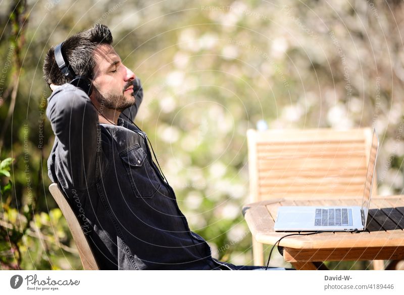 Man with headphones and laptop listening to music Music stream Listening Headphones To enjoy relaxation out Relaxation