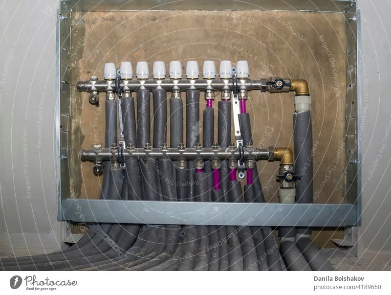 collector case with comb and taps on pipes of heating system connected to it connection internal thermal radiant residential pipleline circulation plumbing warm