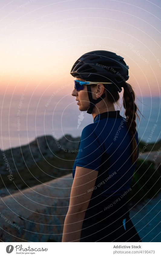 Serious woman with bicycle in highlands nature sport activity cyclist rest break thoughtful calm female active sportswoman helmet mountain alone healthy sporty