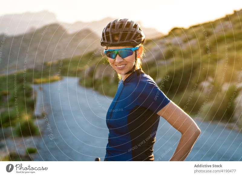 Cheerful woman with bicycle in nature sport activity cyclist rest break calm female active sportswoman helmet mountain alone healthy sporty hobby vitality lady