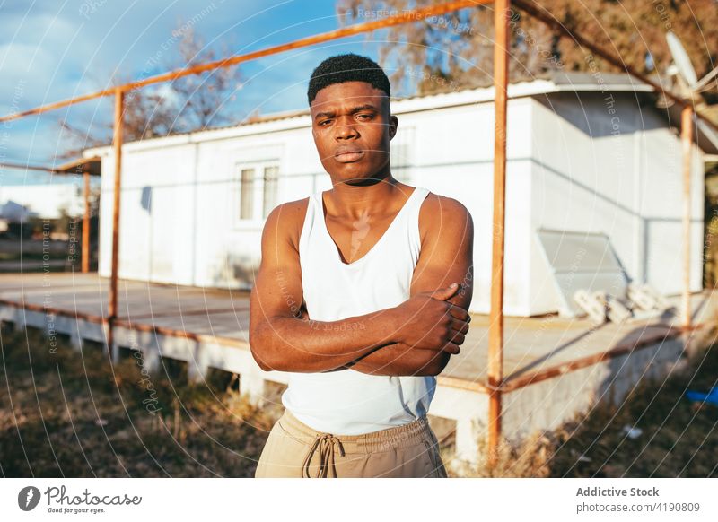 Serious muscular black man near platform in countryside serious masculine macho haircut strong portrait muscle bicep stare old construction african american