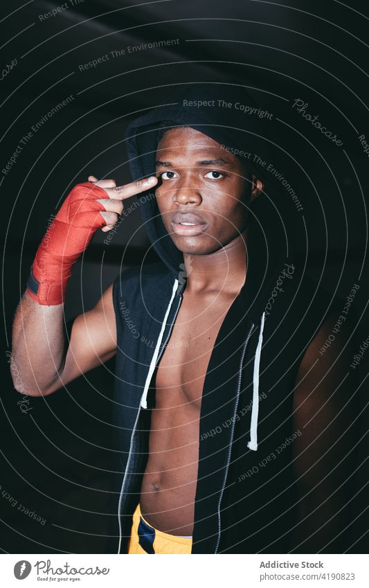 Ethnic boxer with bicep showing fuck gesture sportsman rude aggressive rebel vulgar middle finger offensive portrait abdomen strong power masculine hand wrap