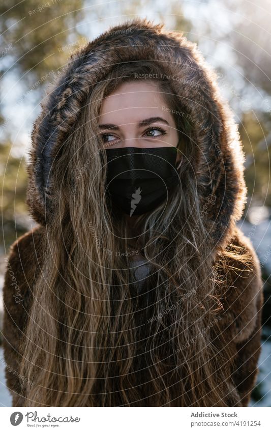 Woman in mask in winter forest woman woods snow protect coronavirus sunny stroll female covid cold season prevent safety weather pandemic epidemic frost stand
