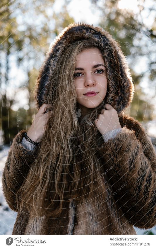 Woman standing in snowy forest woman winter wintertime stroll woods female fur coat warm warm clothes cold season holiday charming outfit outerwear weekend