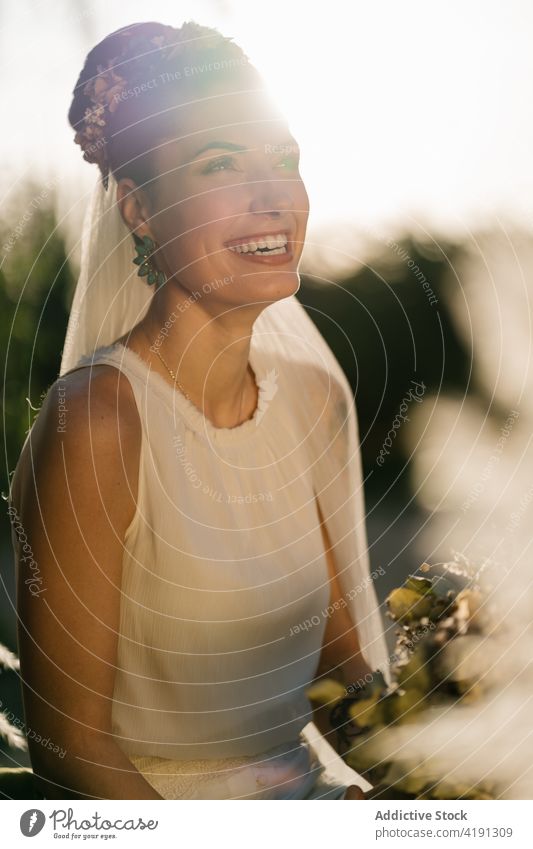 Cheerful bride with flower bouquet in garden bridal cheerful charming wedding white dress newlywed female summer fancy event elegant ceremony romantic woman