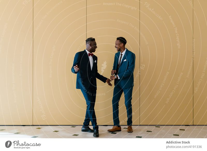 Cheerful groom and best man dancing in room dance newlywed together carefree having fun wedding suit cheerful ethnic black african american male men event