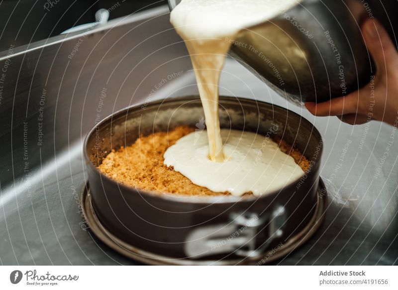 Anonymous chef cooking tasty cheesecake in kitchen prepare cafe tin pour shape form metal dessert sweet delicious culinary gourmet food professional fresh meal