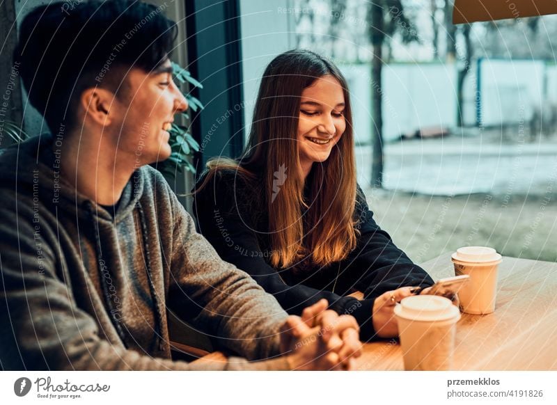 Friends having a chat, talking together, drinking coffee, sitting in a cafe. Young man and woman having a break, relaxing in cafe buy person restaurant