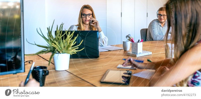 Woman working in the office surprised looking laptop woman looking screen talking phone businesswoman banner web panorama panoramic header coworkers mobile