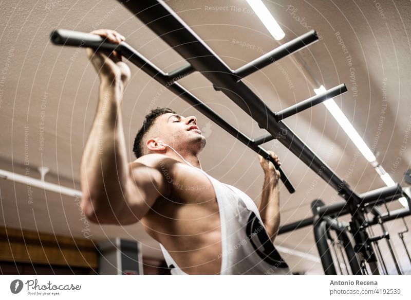 man performs barbell pull-ups in a gym 20s 25-29 years active athlete athletic body caucasian dedication determination exercise exercising fit fitness
