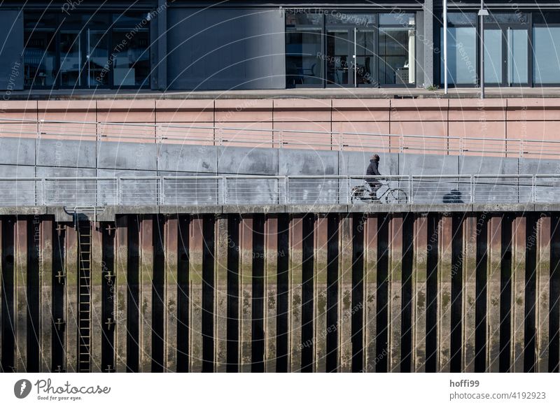 Riding a bike on the quay of a port basin Cycling Bicycle wharf harbour basins sheet pile wall Harbour Transport Movement Lifestyle cyclists Wheel urban