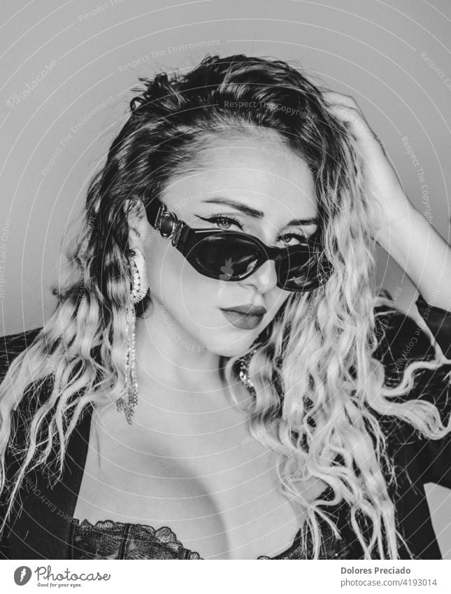 Black and white portrait of a sexy european alternative woman curly hair sunglasses makeup glamour style black female beauty beautiful young lifestyle fun