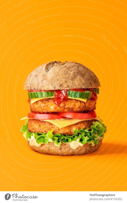 Vegan burger close-up isolated on an orange background. alternative bread cheese cheeseburger color colored consumerism copy space cuisine cut out delicious