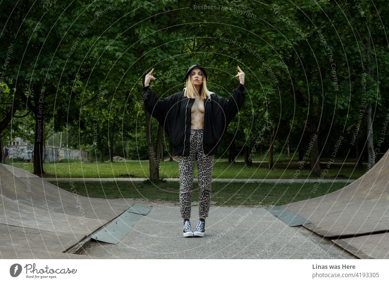 A recreational environment made for skateboarding and for hot barely dressed girls to have fun while showing middle fingers to everyone. Summer is here with all these green trees and green leaves. Wild blonde model just wants to have a good time.