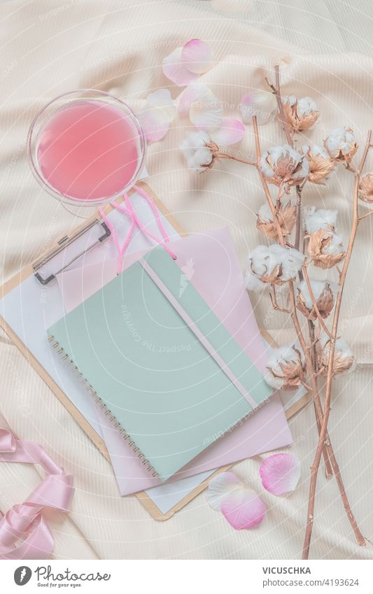 Notebook, Cotton branch and pink drink on beige draped fabric. Top view. Modern aesthetic flat lay . notebook cotton top view modern background beautiful beauty