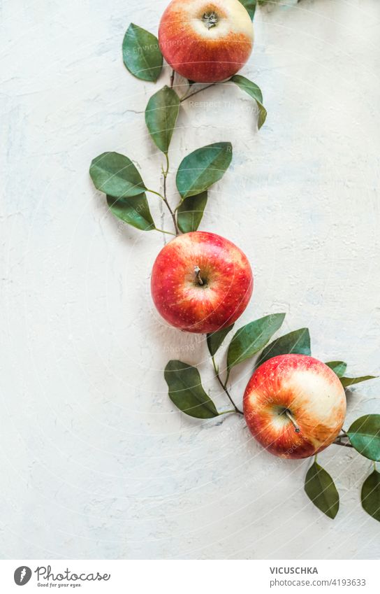 Fresh red apples with green leaves on white desk background. Top view fresh top view fruit minimal nutrition vitamin organic food healthy juicy