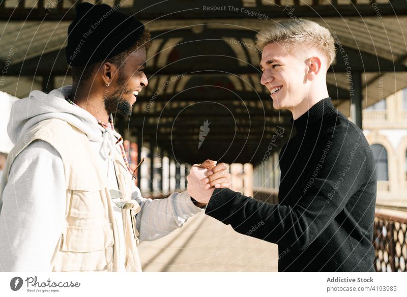 Trendy multiethnic men giving dap after meeting on street handshake greeting trendy friend together city style relationship positive friendship young diverse