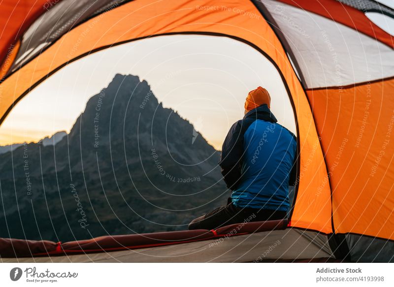 Traveler sitting near tent and enjoying sunset over mountains traveler morning sunrise hiker camper man range male pic d ayous lacs d ayous france pyrenees dawn