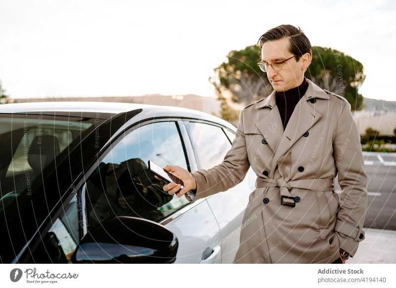 Businessman unlocking car with smartphone businessman automobile remote control using entrepreneur door app male modern online device cellphone gadget