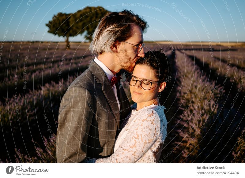 Newlyweds standing close on field at dusk couple newlywed romantic kiss nature valentine face to face occasion affection relationship love peaceful picturesque