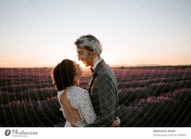Newlyweds standing close on field at dusk couple newlywed sunset romantic nature valentine face to face occasion affection relationship love peaceful