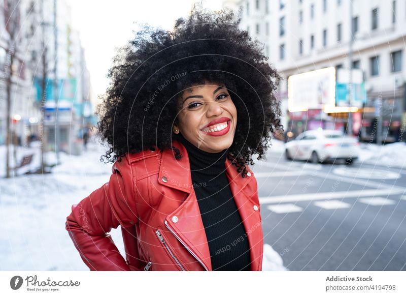 Black woman with afro hair on the street and smiling at camera african american black style city urban optimist individuality curly hair cool delight female
