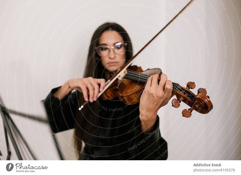 Musician playing violin during rehearsal in studio woman artist instrument serious melody skill instrumental classic female practice violinist player focus