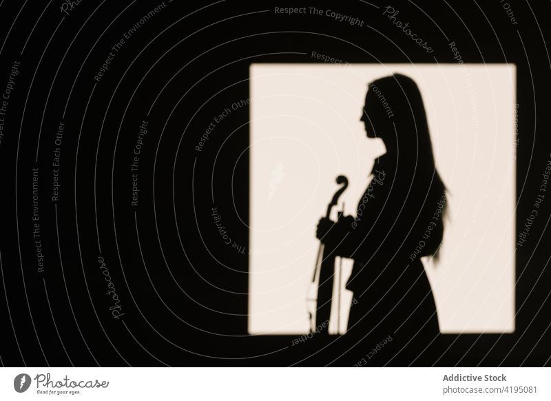 Musician standing with violin in empty room woman musician hobby acoustic leisure silhouette instrument classic art string female think tranquil concentrate