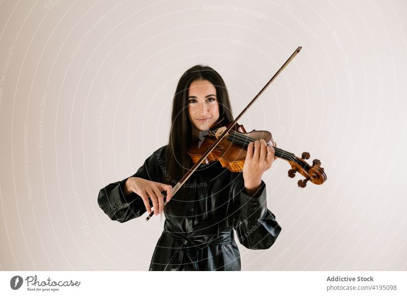 Musician playing violin during rehearsal in studio woman artist instrument melody skill instrumental classic female practice violinist player focus talent sound